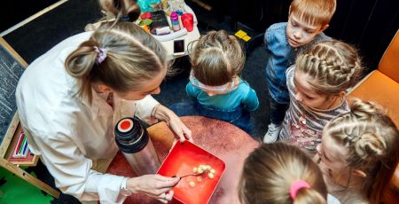 enfants regroupés autour d'une scientifique