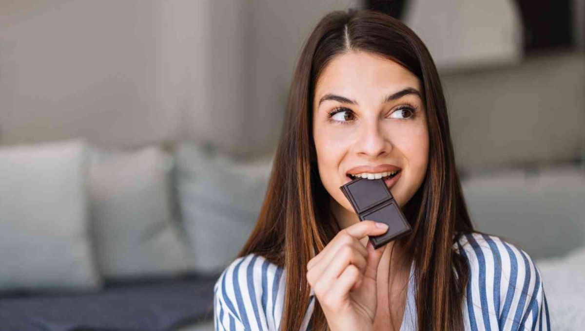 Une femme mange du chocolat noir.