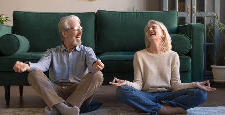 Un homme et une femme sourient en faisant du yoga