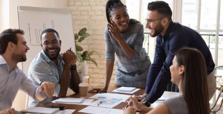 Des collègues sont réunis autour d'une table et sont souriants