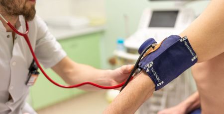 Un médecin prend la tension de son patient.