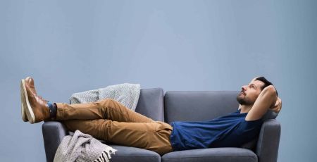 La sédentarité : un homme allongé sur canapé