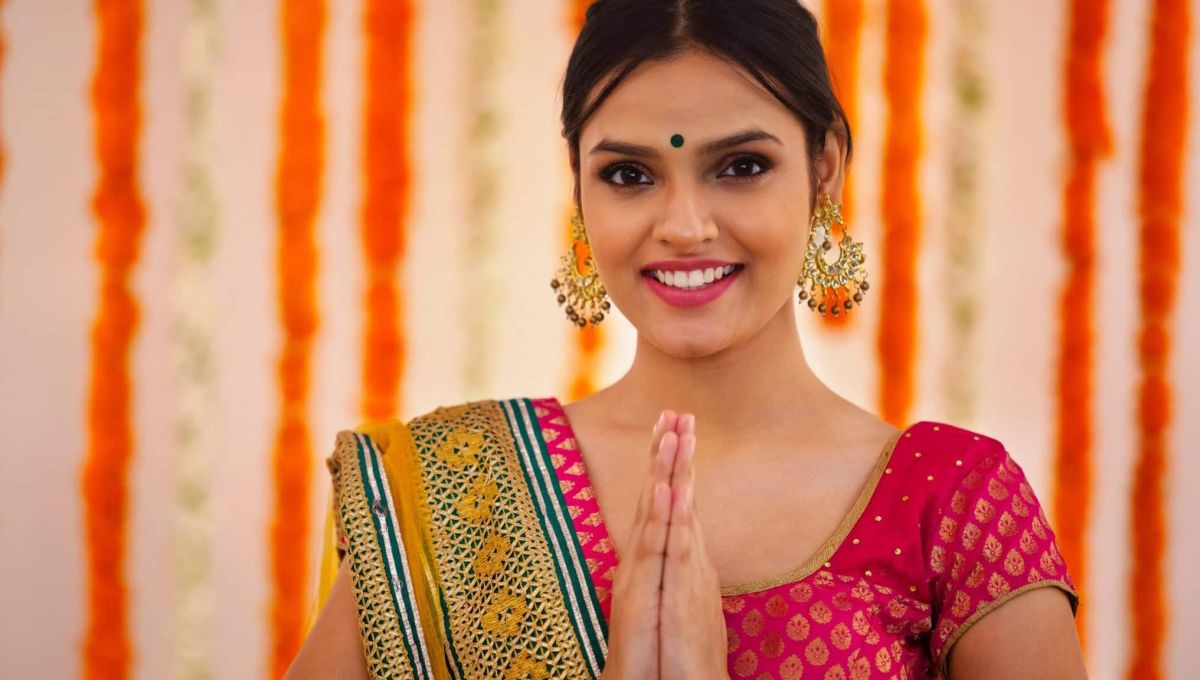 Une jeune femme Indienne fait le geste de Namasté