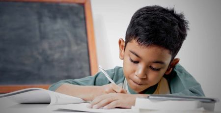 Un petit garçon fait ses devoirs. Dyslexie.