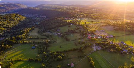 Vue du ciel, des prés entourées de haies avec quelques maisons et fermes