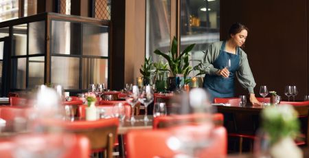 Une jeune fille dresse une table.