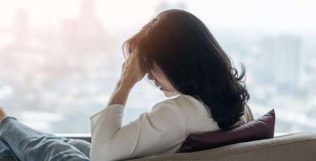 Femme fatiguée face à une fenêtre