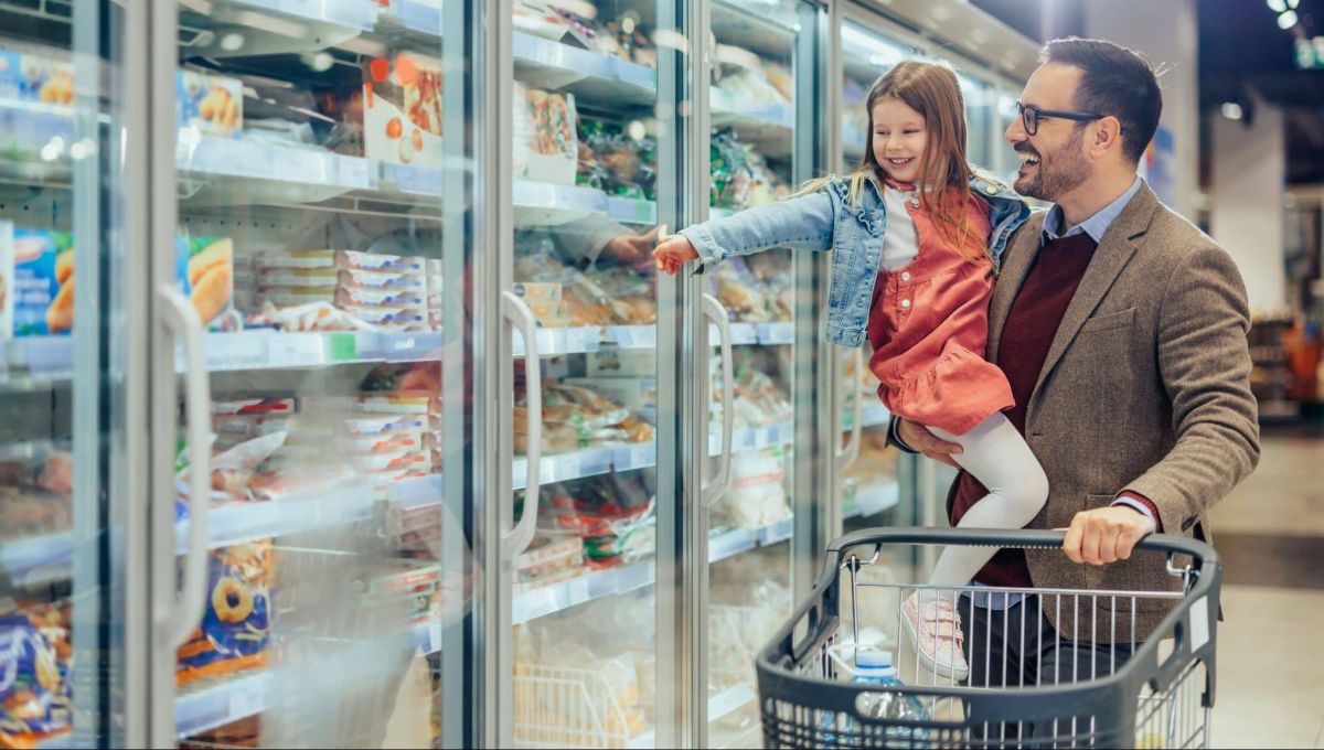 Père et fille devant congélateur supermarché