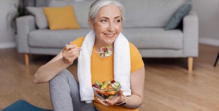 Une yogini qui mange un bol de fruits.