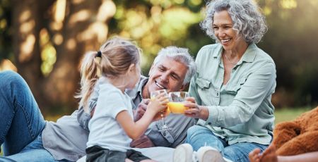 Une famille pique-nique et boit un jus d'orange.