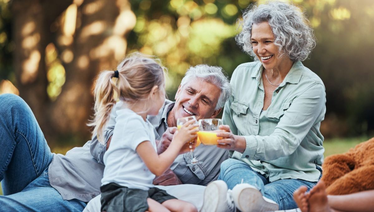 Une famille pique-nique et boit un jus d'orange.