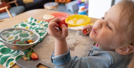 Un enfant mange des fraises.