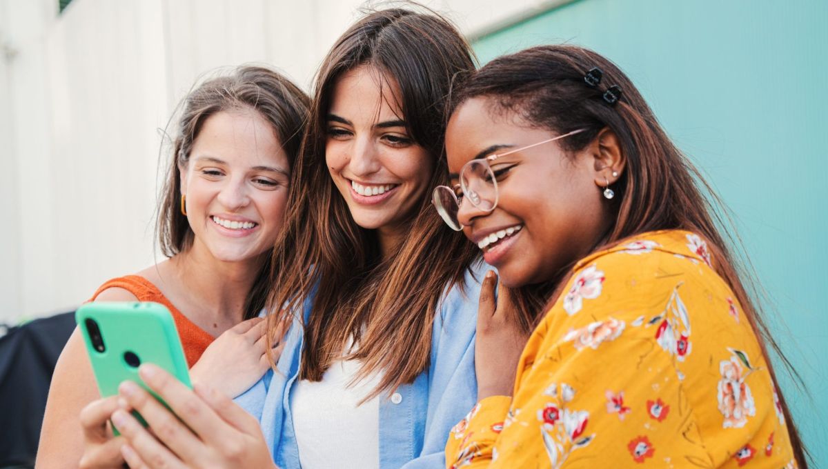 Trois adolescentes avec un téléphone.