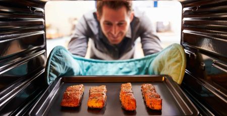 un homme sort du poisson du four