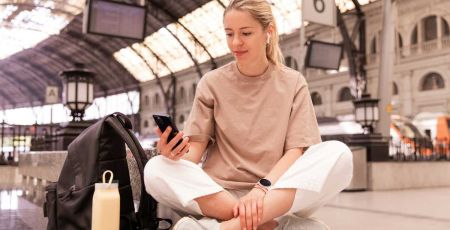 Ado et son téléphone dans une gare