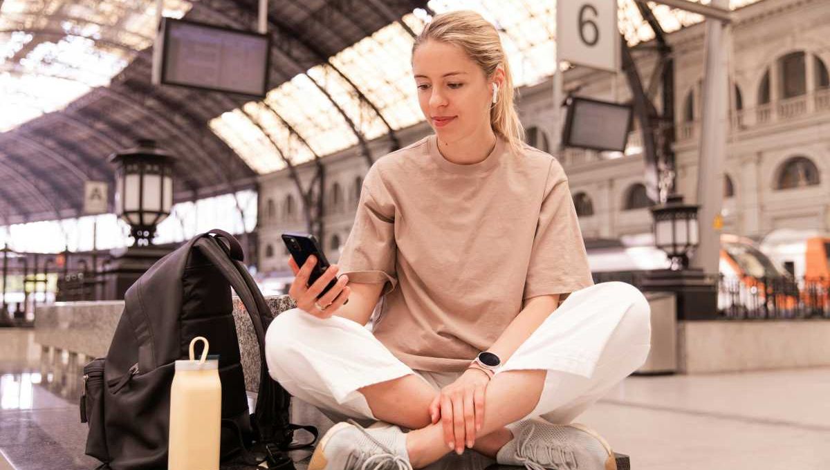 Ado et son téléphone dans une gare