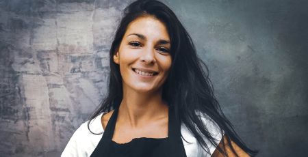 Justine Moure la créatrice de la marque Junnyporte un tablier noir tout en souriant