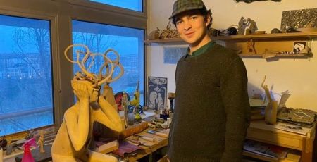 garçon et sculpture bois dans atelier