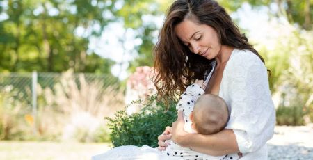 Une femme allaitant son bébé en extérieur