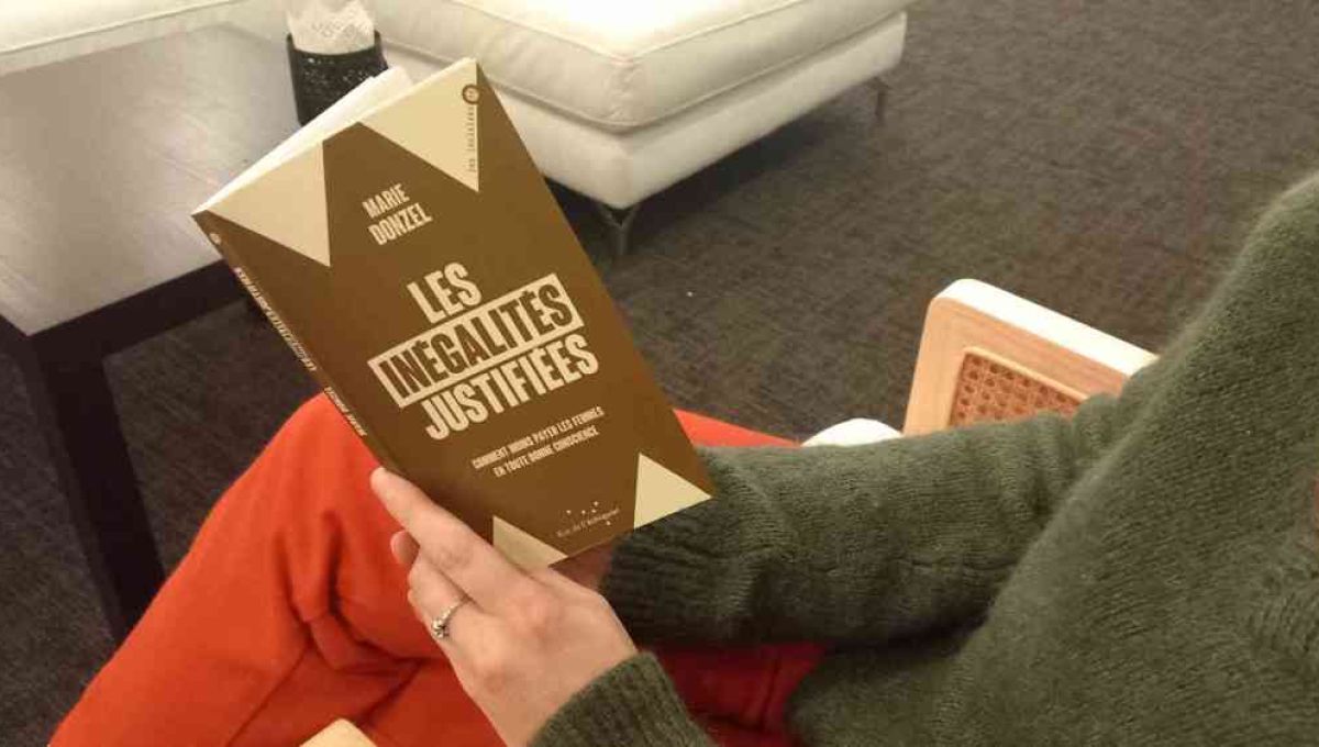 Livre : “Les inégalités justifiées”. Une personne est assise sur une chaise elle tient le livre de Marie Donzel