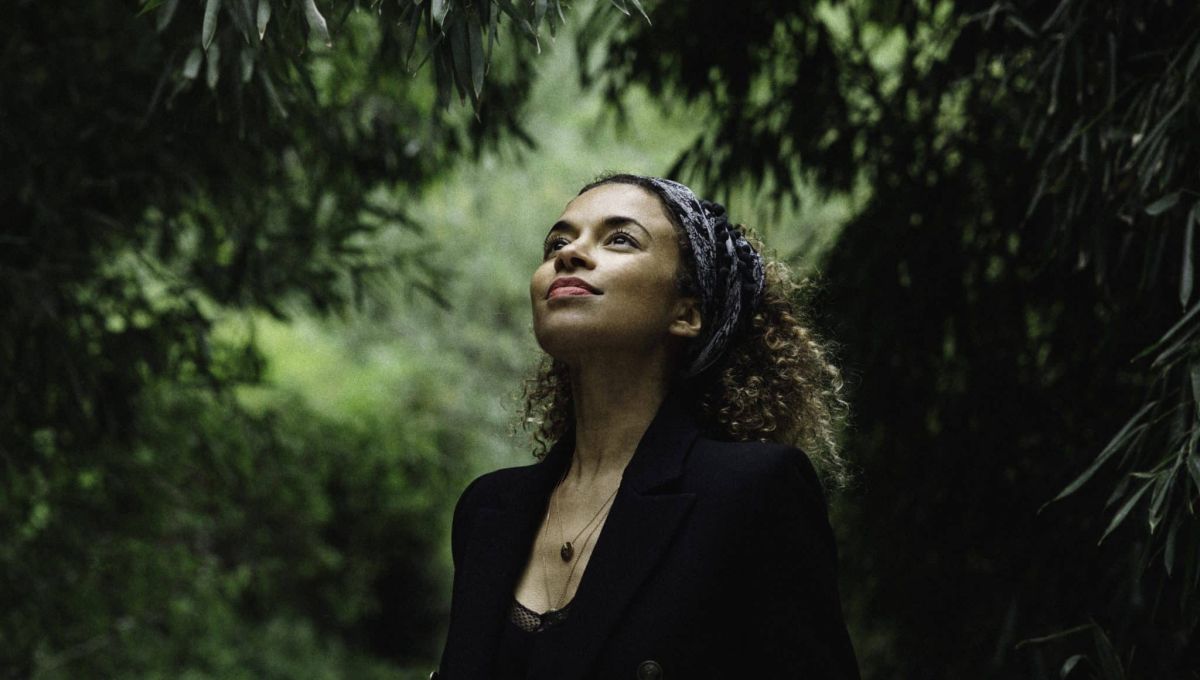 L'artiste Annie Lalalove en pleine nature regarde avec un sourire vers le ciel