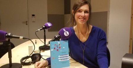 Lyne Derose pose avec le livre qu'elle a coécrit