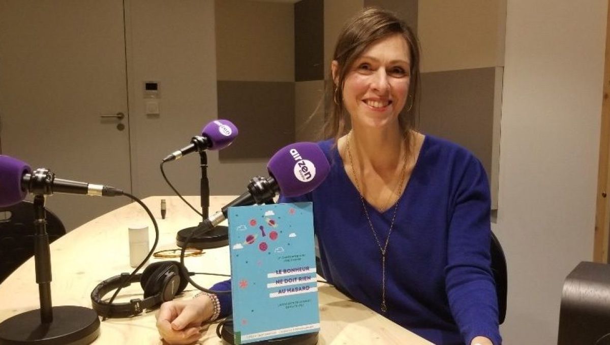 Lyne Derose pose avec le livre qu'elle a coécrit