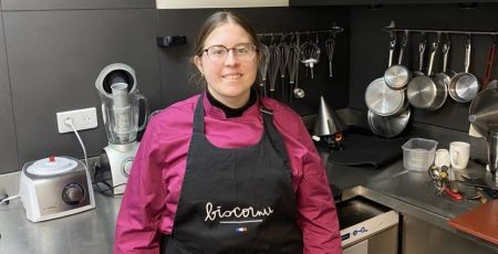 Lorraine chef de partie chez Biscornu, en cuisine, porte un tablier noir