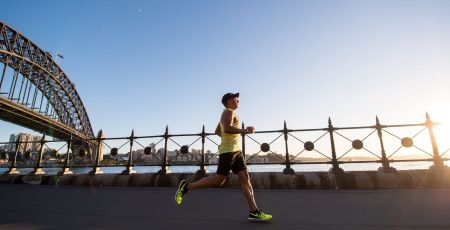 man in yellow tank top running near shore