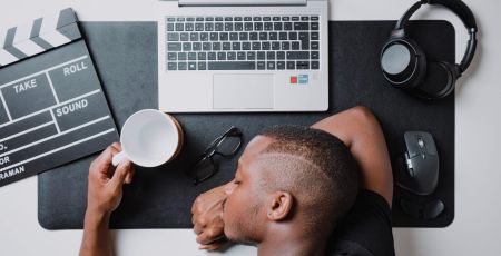 a man sitting at a desk with a laptop and headphones