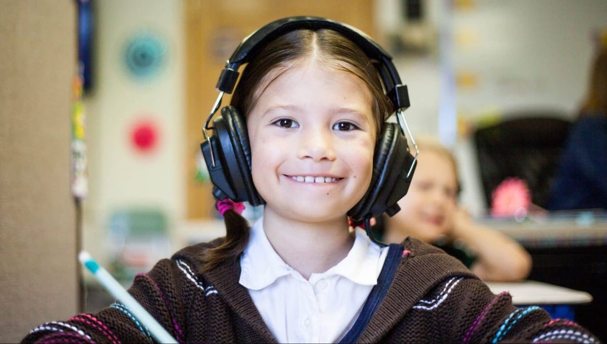 Une enfant porte une casque pour écouter la musique.