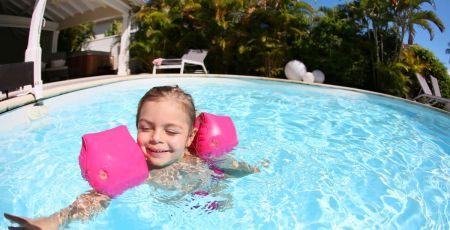 Enfant dans la piscine avec brassards - crédit photo : goodluz via Adobe Stock