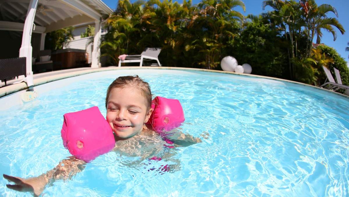 Enfant dans la piscine avec brassards - crédit photo : goodluz via Adobe Stock