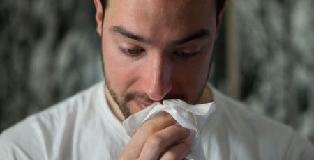 Un jeune homme se mouche