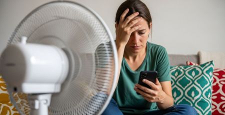 Femme qui a chaud devant un ventilateur