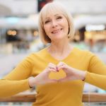 Femme de 60 ans qui fait un coeur avec les mains