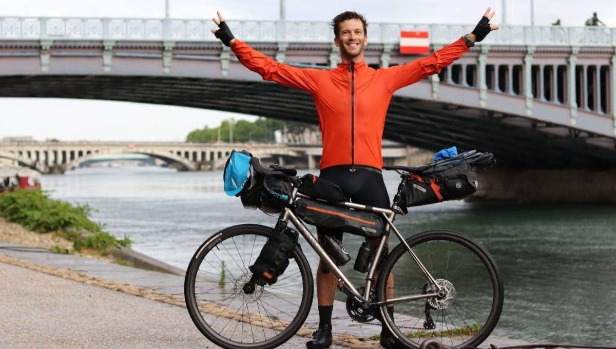 Charles Steinmyller devant son vélo à Lyon au bord du Rhône