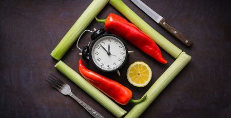 Ingrédients, légumes posés sur une table, avec une horloge au milieu