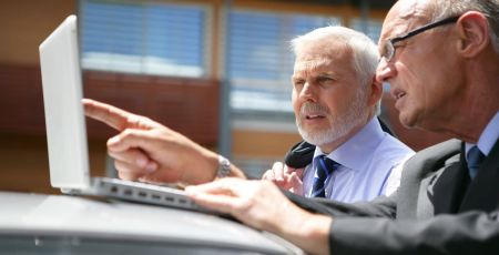 deux hommes d'affaires senior avec ordinateur portable