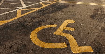 Disabled parking. Accessible parking spot. Blue badge. Yellow wheelchair sign on the ground