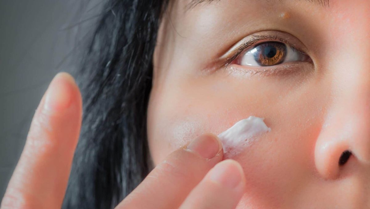 femme s'appliquant de la crème sur le visage