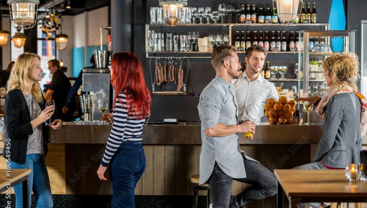 Friends Talking While Having Their Drinks In Bar