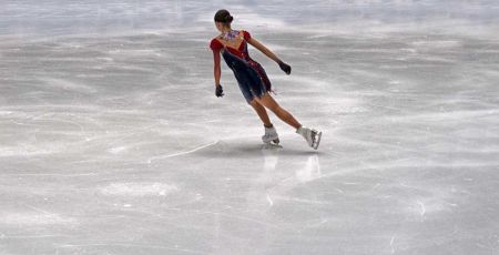 Une patineuse de dos, debout sur la glace.