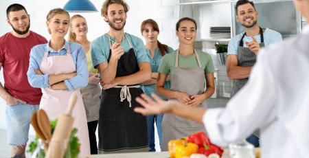 Group of people and female chef at cooking classes