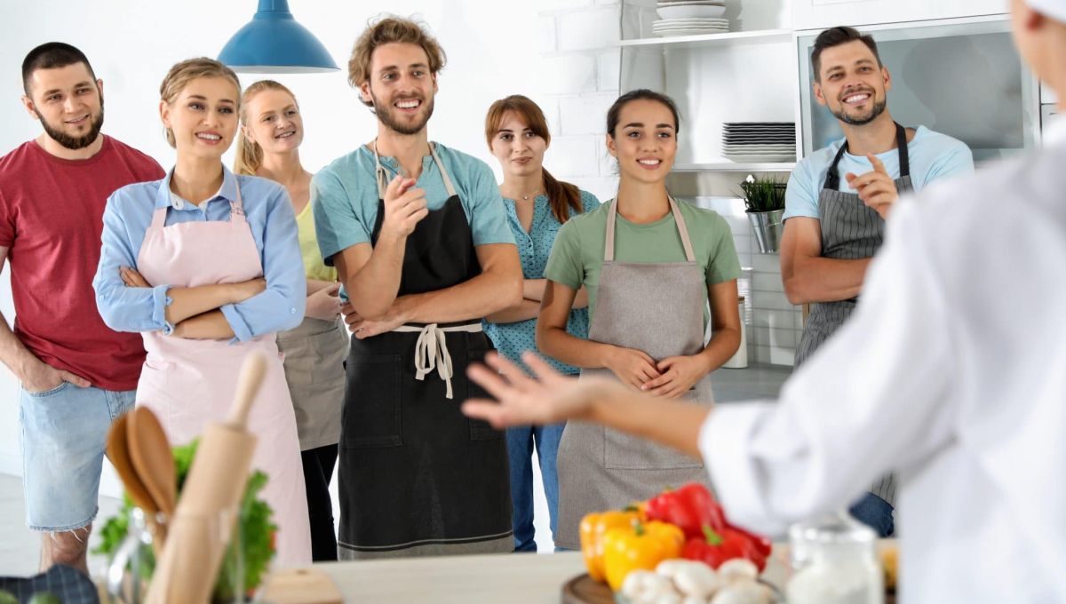 Group of people and female chef at cooking classes