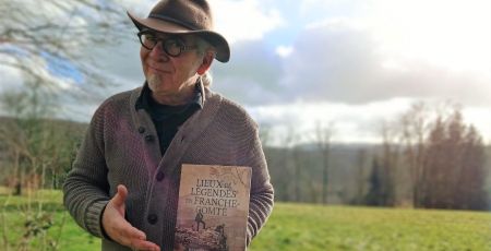 Homme avec chapeau tenant livre dehors