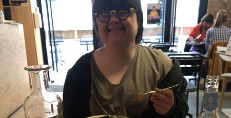 Jeanne au Reflet, souriante devant son plat