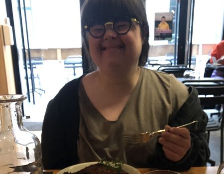 Jeanne au Reflet, souriante devant son plat