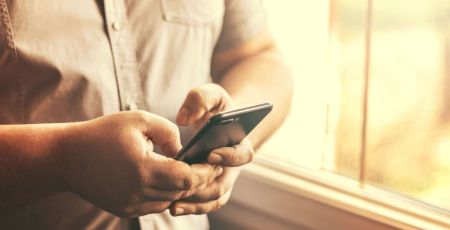 Jeune homme utilisant un téléphone portable en intérieur