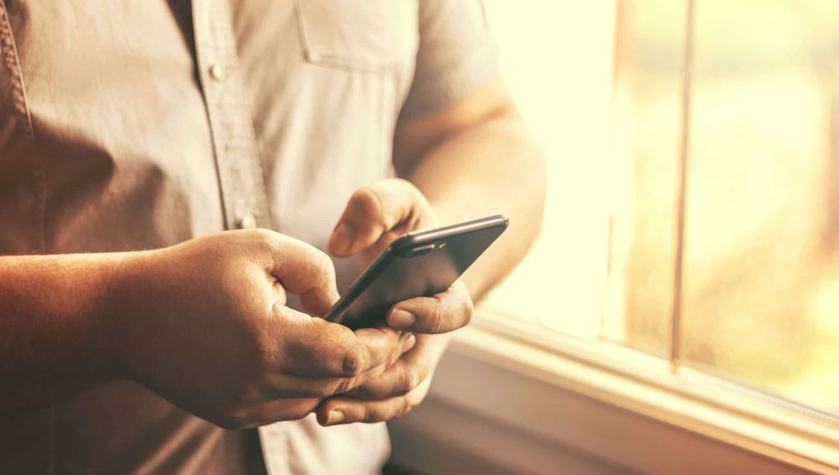 Jeune homme utilisant un téléphone portable en intérieur